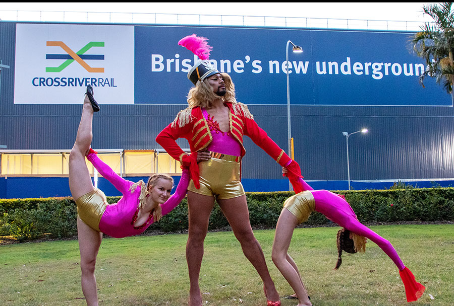 three dancers in colourful costumes in front of the Roma Street acoustic shed